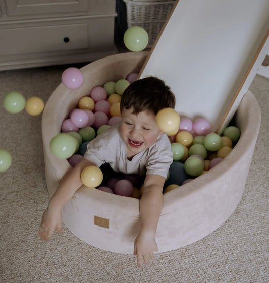Child playing in MeowBaby® Baby Foam Ball Pit 30 cm - Spring, filled with colorful balls for sensory play and motor skill development. Soft, washable, CE certified, with stable foam construction.