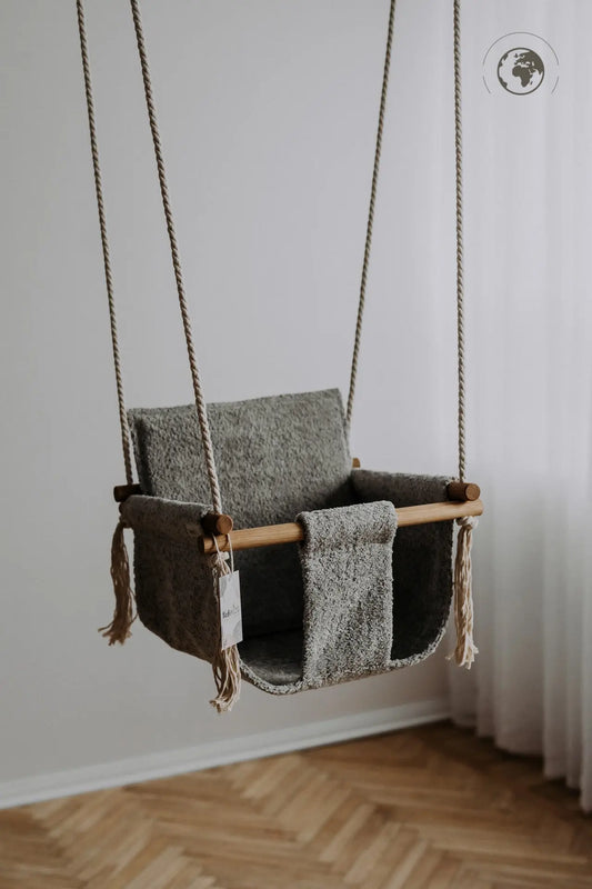 A luxurious Baby Swing in Bouclé Stone Grey, made from recycled materials and oak wood poles, ensuring safety and style for your child. Dimensions: 41 x 41 cm.