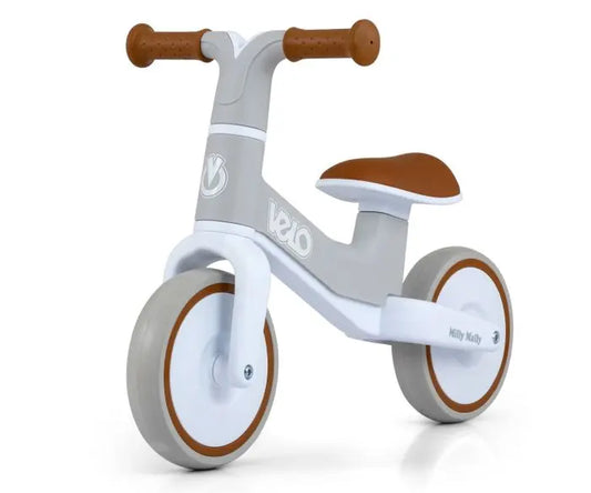 A white and brown tricycle with close-ups of wheel, seat, and sign. VELO balance bike for kids, featuring puncture-proof 7-inch wheels, steering limiter, and comfortable seat. Ideal for ages 18+ months.