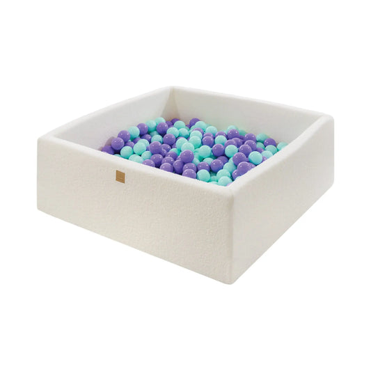 A white foam box filled with blue and purple balls, ideal for sensory therapy and motor skill practice. Boucle White Square Balls Pit 110x110x40cm - 400 Heather Mint Balls.