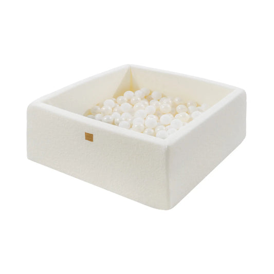 A white square ball pit filled with white pearl balls, ideal for sensory therapy and motor skill development. Made from soft, anti-allergic foam, washable, and designed for safe play. Dimensions: 90x90x40cm.