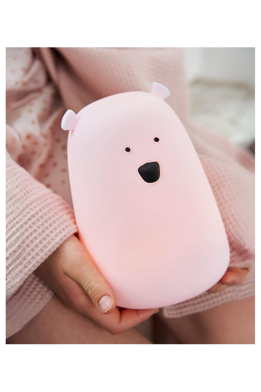 Person holding a pink Big Bear silicone lamp with remote control, soft and safe for children, featuring 7 colors, touch activation, and awards.