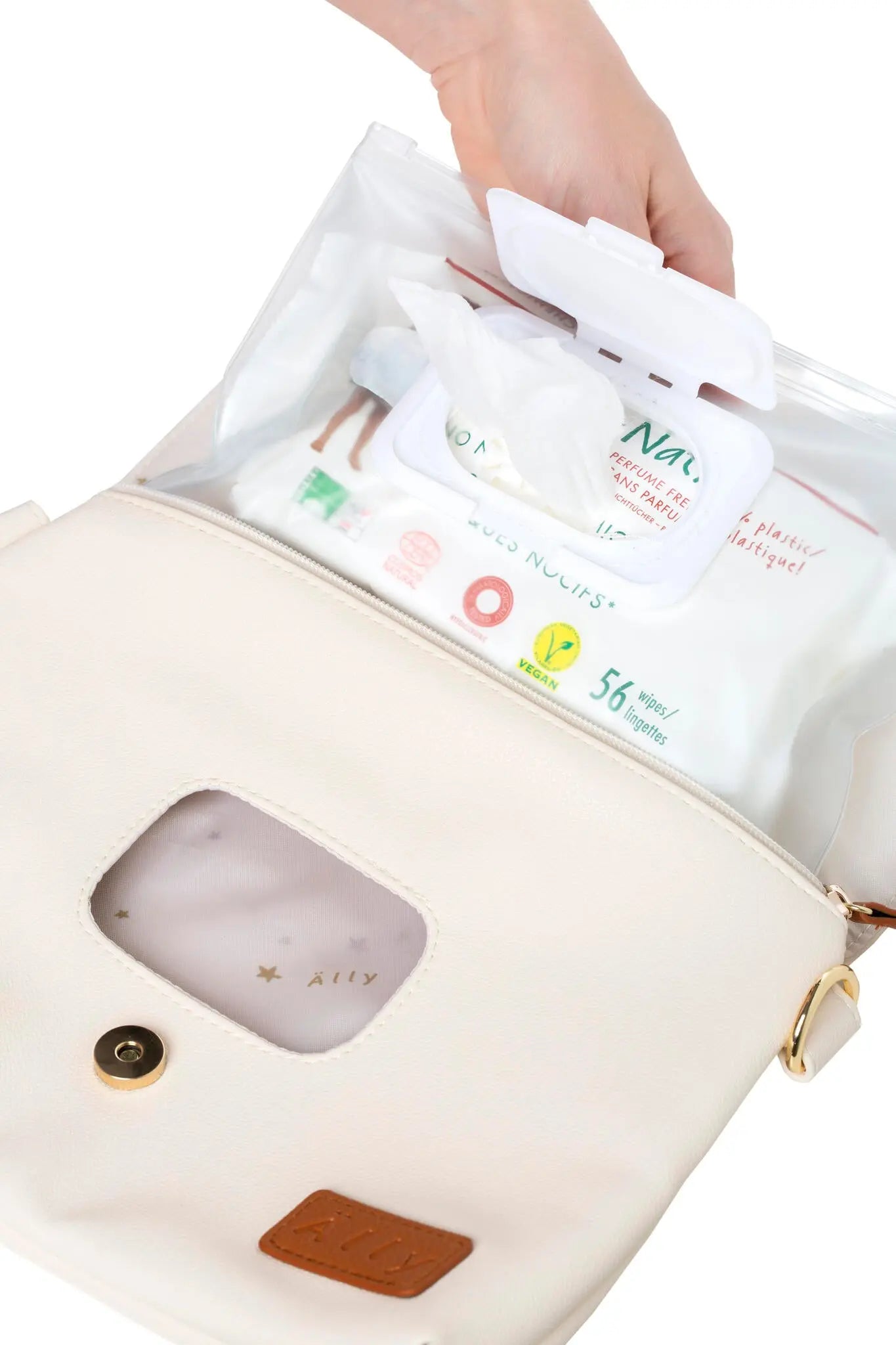 A hand holding a baby wet wipes bag, featuring a long strap and wrist strap for versatile carrying. Cappuccino handbag, light at 0.3 kg, with a removable wet wipes pocket.