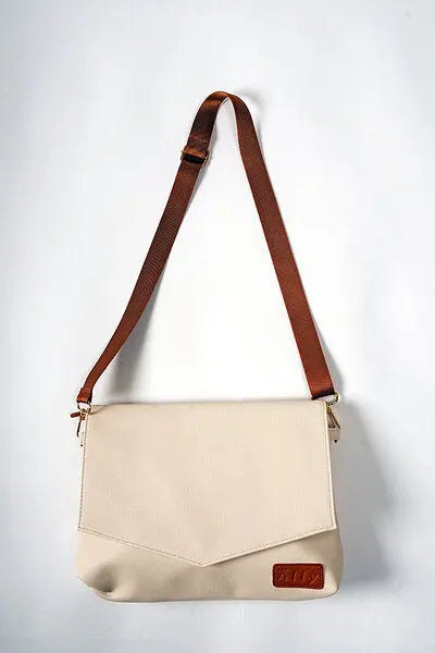 A white handbag with brown straps, featuring a long and wrist strap for versatile carrying options. Lightweight at 0.3 kg, designed in Europe, with a removable wet wipes pocket.