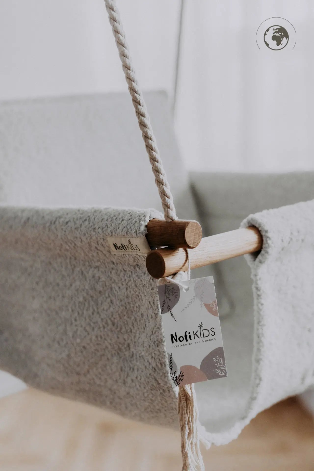 A luxurious Baby Swing in Bouclé Ice Grey, made from recycled materials and oak wood, exuding safety, comfort, and style for your child.