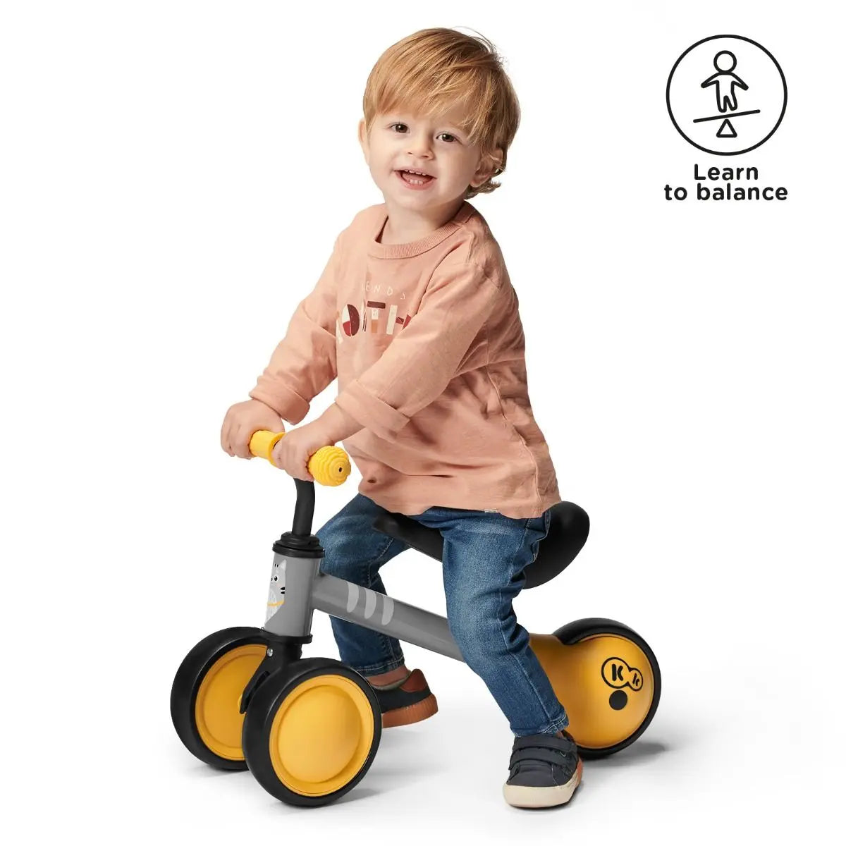 Toddler on a yellow balance bike with kitten print, rubber non-slip handles, adjustable saddle, and sturdy steel frame for safe and fun play.