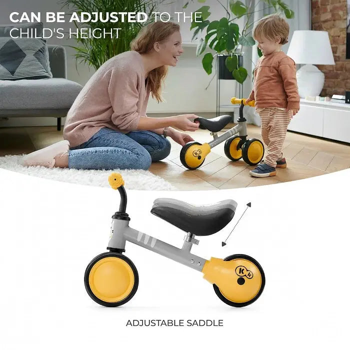 A woman and child on a yellow balance bike CUTIE, featuring a kitten print, adjustable saddle, rubber handles, and a durable steel frame for safe play.