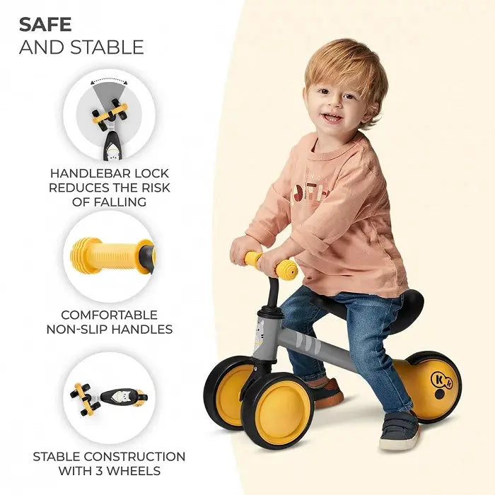 Child on a tricycle with kitten print, rubber handles, adjustable saddle, ball-bearing rear wheel, and strong steel frame. Balance Bike CUTIE - Yellow for toddlers learning balance.