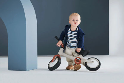 A toddler on a TOVE balance bike with puncture-resistant wheels, lightweight construction, and adjustable seat for ages 18 months and up.