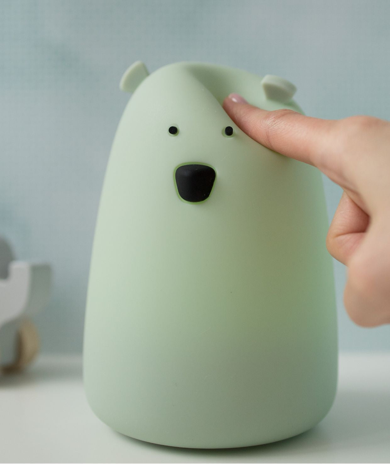 A white silicone lamp in the shape of a teddy bear with protruding ears and a round belly, perfect for bedtime routines and comforting children.