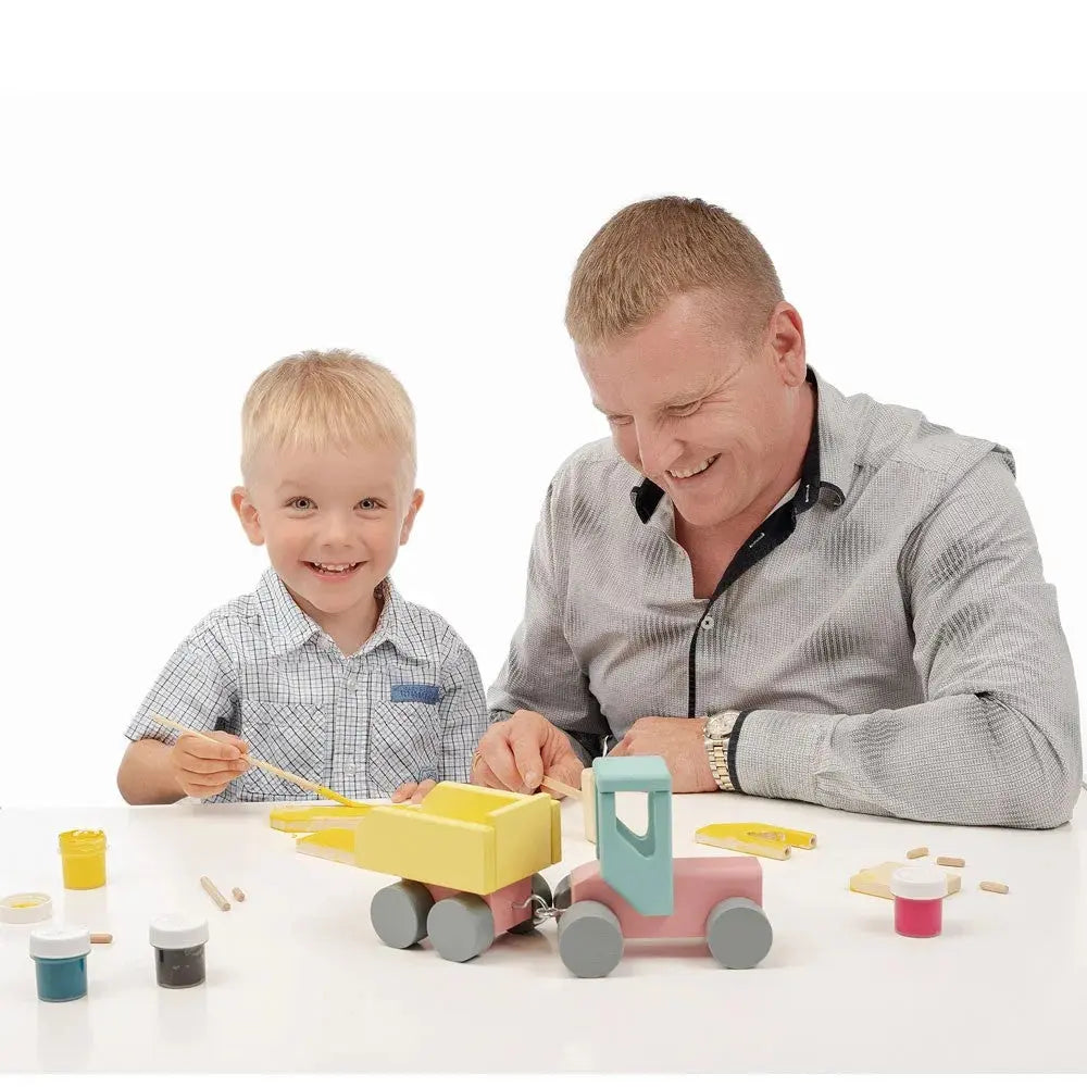 A man and boy assemble a DIY Wooden Tractor set, engaging in hands-on learning and play. Meet Tonu, the durable birchwood tractor fostering creativity and problem-solving skills for children aged 3 and above.