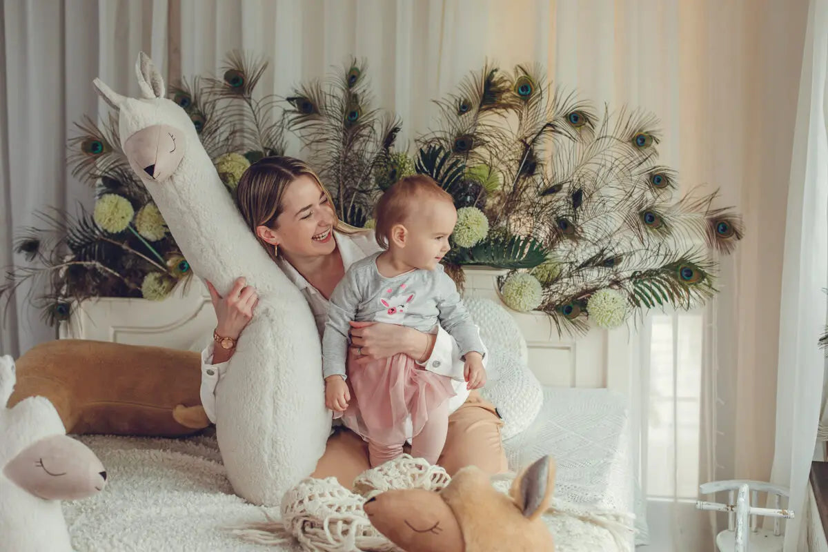 A woman holding a baby, a woman hugging a stuffed animal, and a stuffed animal with a face drawn on it. Indoor setting with person and baby tags.