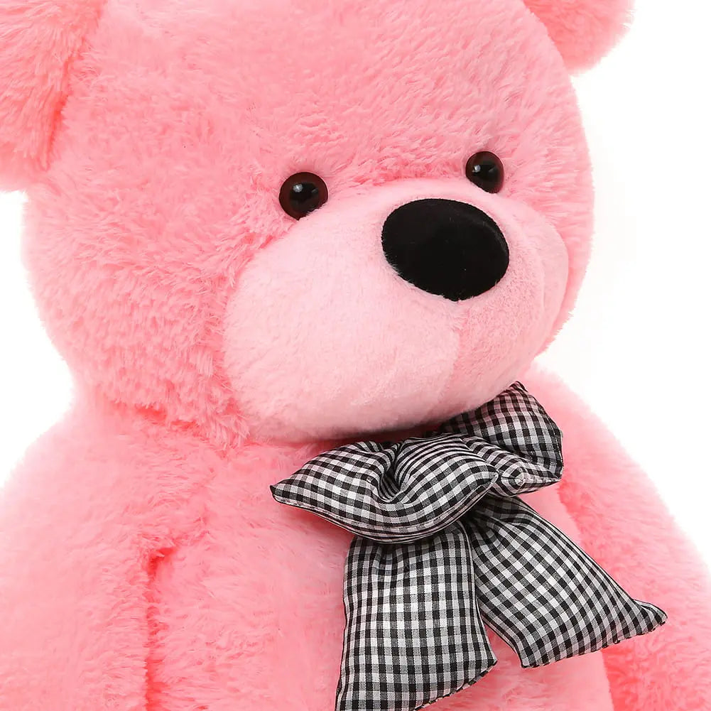 A 180 cm Giant Teddy Bear made from soft fur, featuring a black and white checkered bow, perfect for safe hugging. EU safety certified, washable, and crafted in Europe. Ideal for gifting joy and warmth.