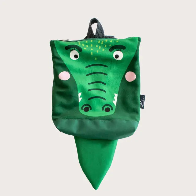 A cartoon crocodile kids backpack with a cute face design. Made of velvet and waterproof polyester, featuring adjustable straps and zipper closure. Ideal for ages 2-6.