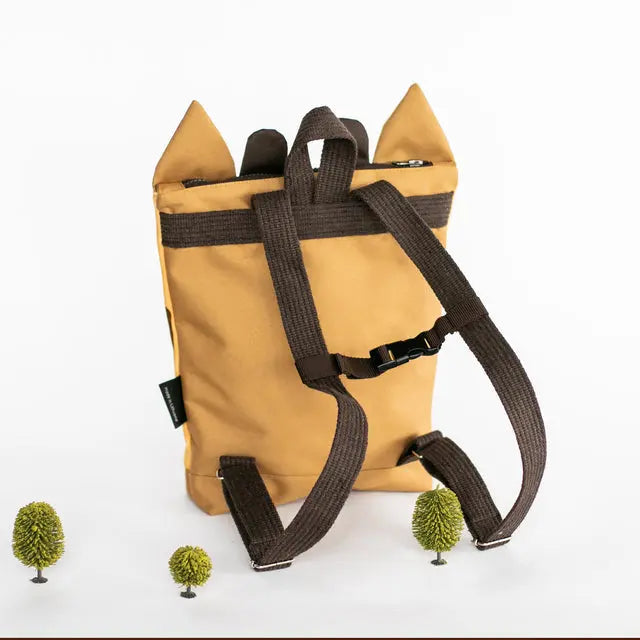 A kids backpack featuring a giraffe design, with velvet top and waterproof polyester bottom. Adjustable beige shoulder straps, zipper closure, and two inside slip pockets.