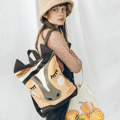 A girl in a sun hat holds a string bag of oranges, showcasing the Kids backpack - Horse. Velvet top with a Horse design, waterproof bottom, and adjustable straps for comfort.