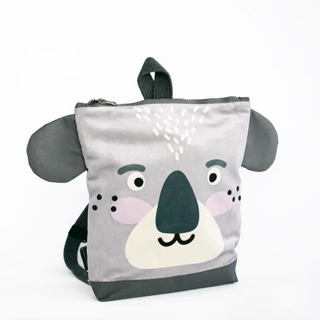 Kids backpack featuring a grey koala face design. Made of velvet and waterproof polyester with adjustable shoulder straps. Ideal for outdoor adventures with a playful touch. Dimensions vary for different age groups.