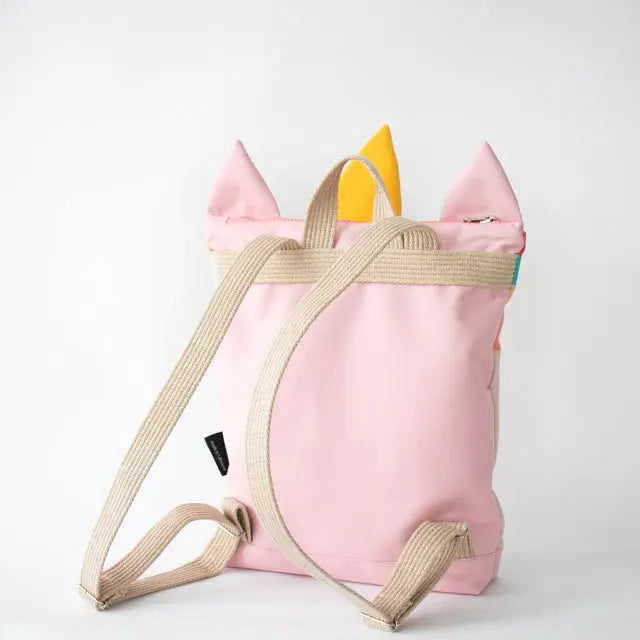 Kids backpack featuring a pink design with unicorn details, adjustable shoulder straps, and two inside slip pockets. Available in small and large sizes for ages 3-9.