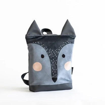 A small grey and black kids backpack featuring a wolf face design. Made of velvet and waterproof polyester with adjustable straps and zipper closure. Ideal for young explorers aged 3-9.