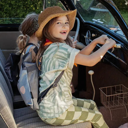 Two girls in a car, one wearing a sun hat, driving. A girl in a hat driving a car. A girl with a backpack sitting in a car. Close-up of tie and suit. Person in green and white shirt.