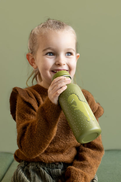 A girl holds a green stainless steel bottle with a dinosaur design. Durable, leak-proof, and kid-friendly cap. Perfect for outings with kids. Dimensions: 20 cm x 6.5 cm.