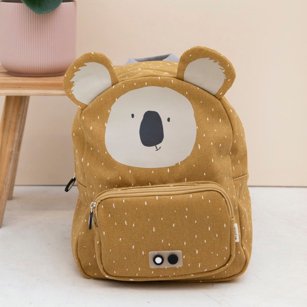 A backpack featuring a bear face design, Mr. Koala, ideal for kids' adventures. Adjustable padded straps, chest strap, water-repellent cotton material, 7.5L capacity. Dimensions: 31 x 23 x 10 cm.