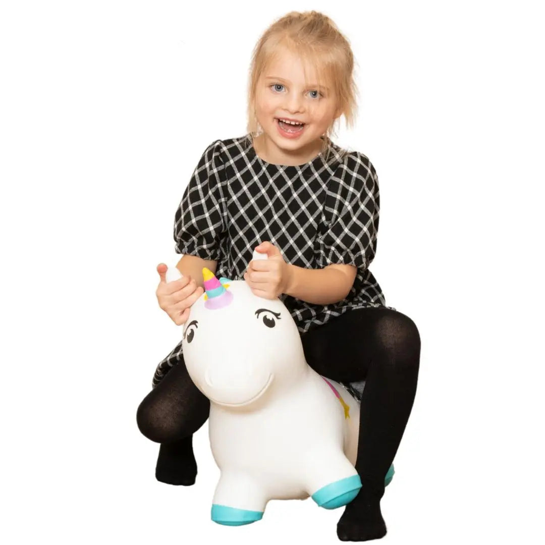 A child happily sits on a unicorn toy, promoting balance and coordination skills. Inspiring active play with a Batmobile design, encouraging imagination and muscle development.