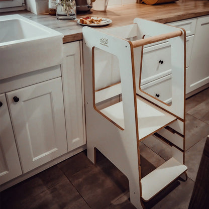 A white Plywood Kitchen Helper Scandi in a kitchen, featuring adjustable platform heights for child safety and independence, made of birch plywood with melamine coating.