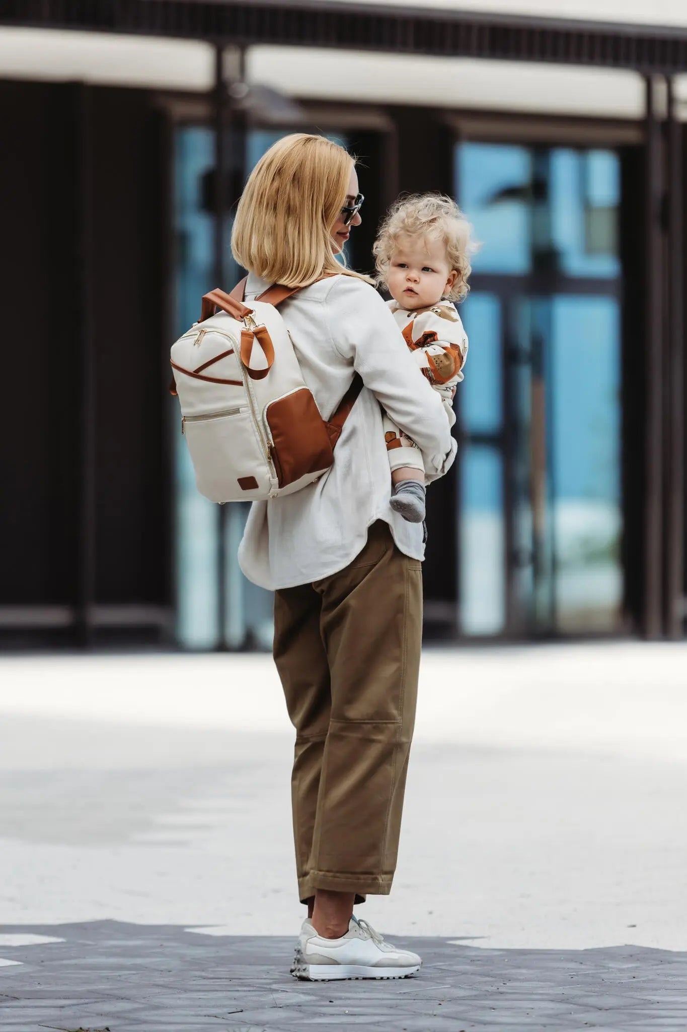 A stylish Small Diaper Backpack in Cappuccino color, designed for convenience and organization. Lightweight PU vegan leather with multiple pockets for essentials.