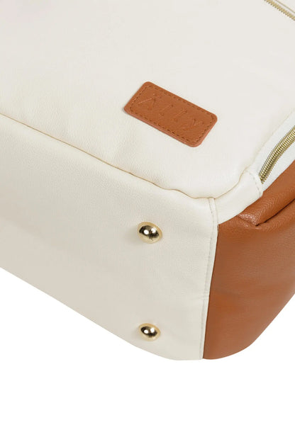 A close-up of a tan diaper backpack with a front zippered pocket, YKK zippers, and adjustable shoulder straps. Stylish, lightweight, and designed for on-the-go parents.