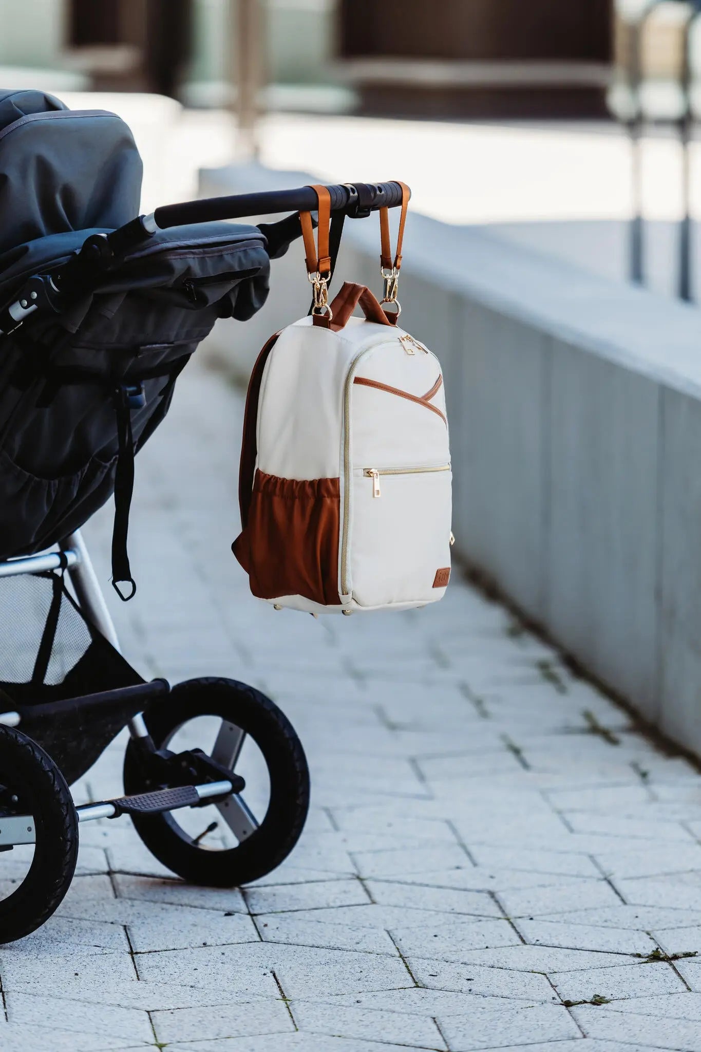 A compact Cappuccino Diaper Bag with stroller straps, featuring a backpack design with multiple pockets, YKK zippers, and thermal-lined compartments for baby essentials. Designed for style, convenience, and durability by Ally Scandic.