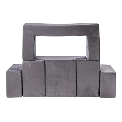 Soft, modular Velvet Bricks Set for children's play, featuring grey rectangular blocks with a handle and cushion. Promotes creativity, safety, and multifunctionality in play spaces.