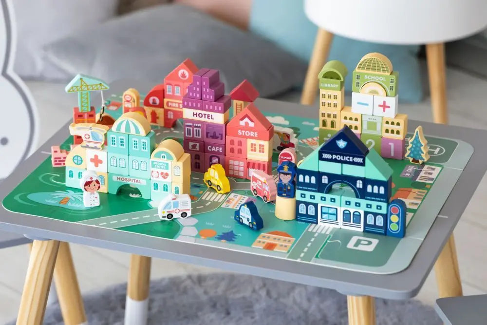 Wooden Blocks + Base City Set, 121 Pieces, on table: toy city, vehicles, police station, ambulance, guidebook for creative play and skill development.