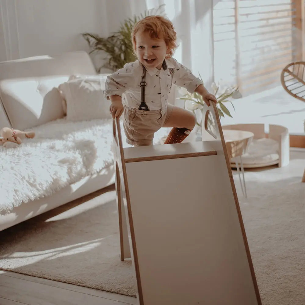 Child climbing on Wooden Indoor Scandi Slide, 87x46cm, featuring stable structure, smooth edges, and comfortable handles for safe play.