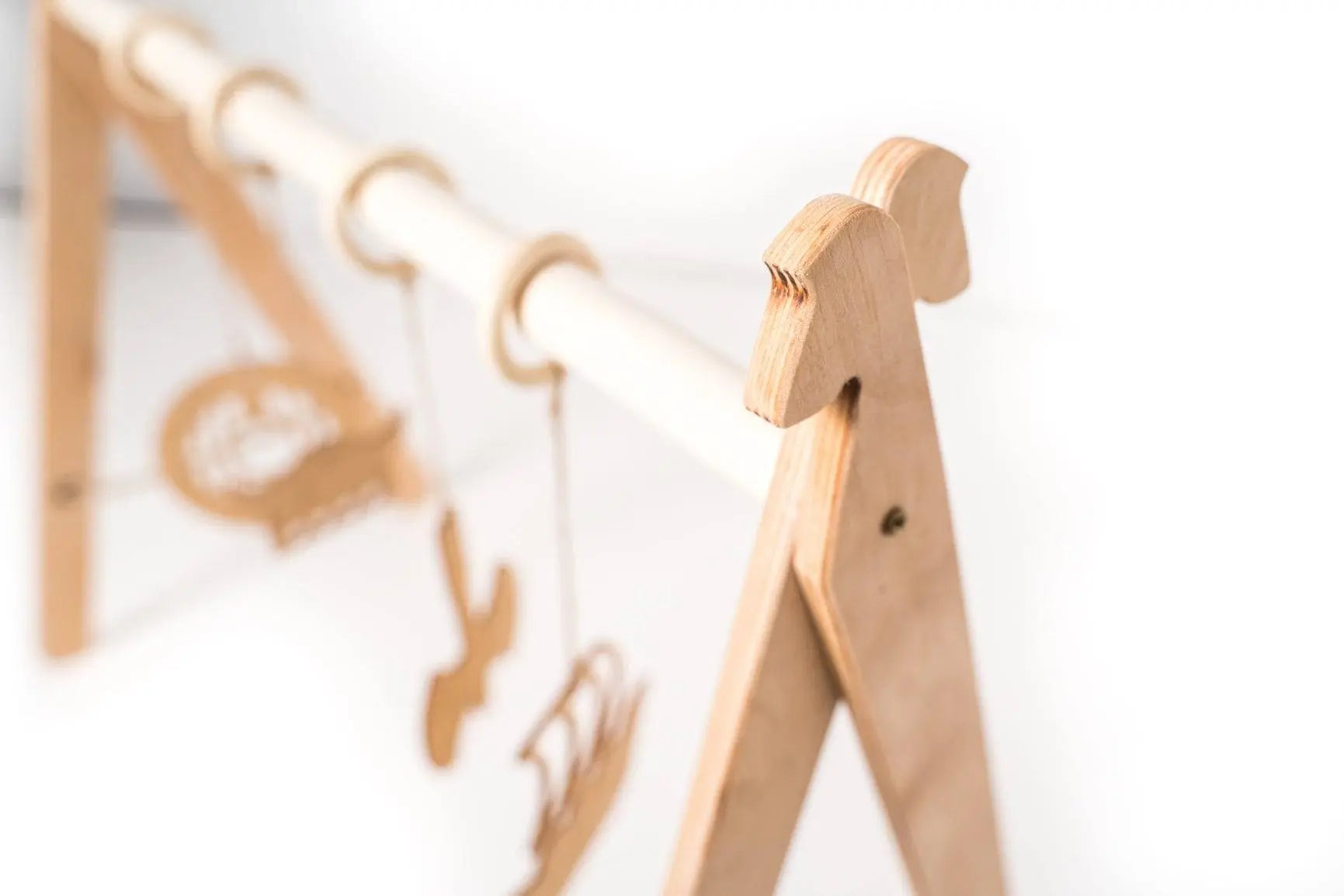 A wooden baby mobile with Viking-themed toys, part of the Wooden Play Gym for Baby set promoting cognitive and motor skills development.