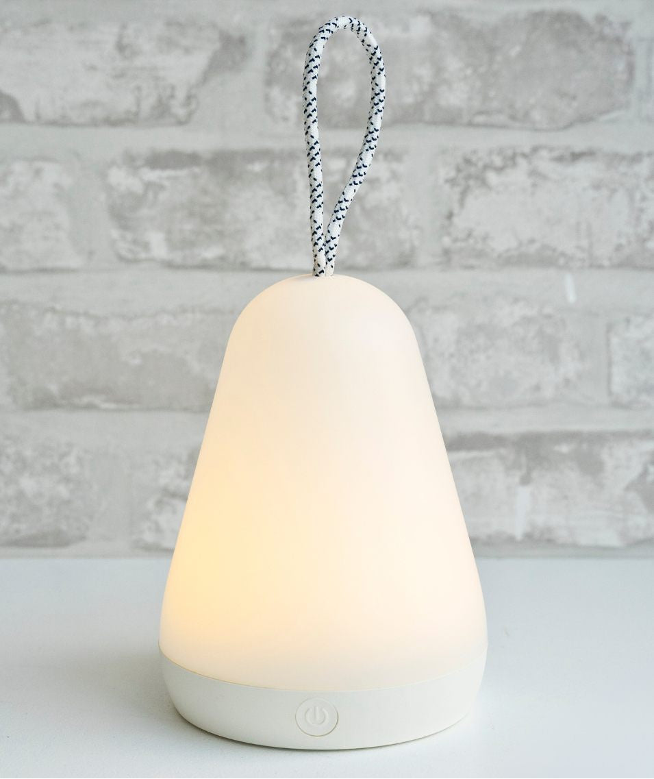 A multifunctional Lantern lamp in white, featuring a rope handle for hanging, remote control for light intensity, and 10-hour warm glow. Dimensions: 16 x 11.5 x 11.5 cm.