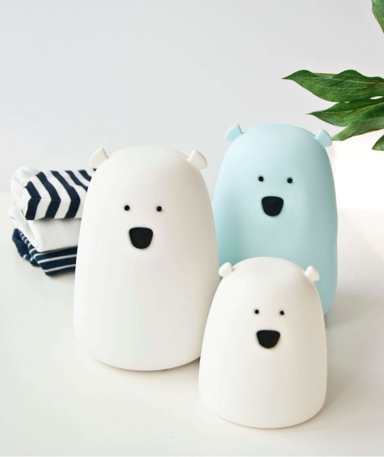 A white silicone lamp shaped like a friendly bear, emitting a warm glow. Child-safe with touch control, 7 color options, and long battery life. Dimensions: 10 x 8.6 x 8.6 cm.