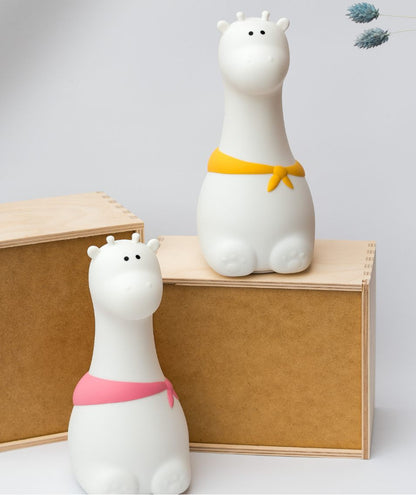 A white giraffe silicone lamp, soft to touch, lights up in 7 colors, with 12-hour lighting time, USB charging, and safe for children.