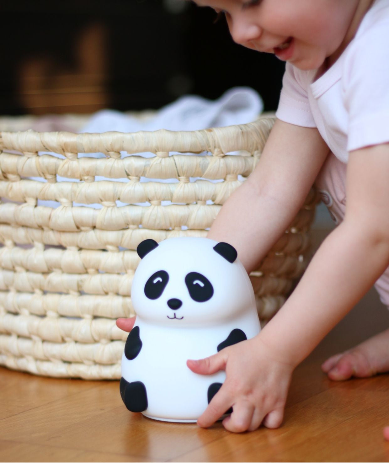 A child holds a Panda Silicone Lamp, a soft, touch-responsive night light. Safe for kids, it changes shape, lights in 7 colors, and auto shuts off after 2 hours. USB Type-C charging.