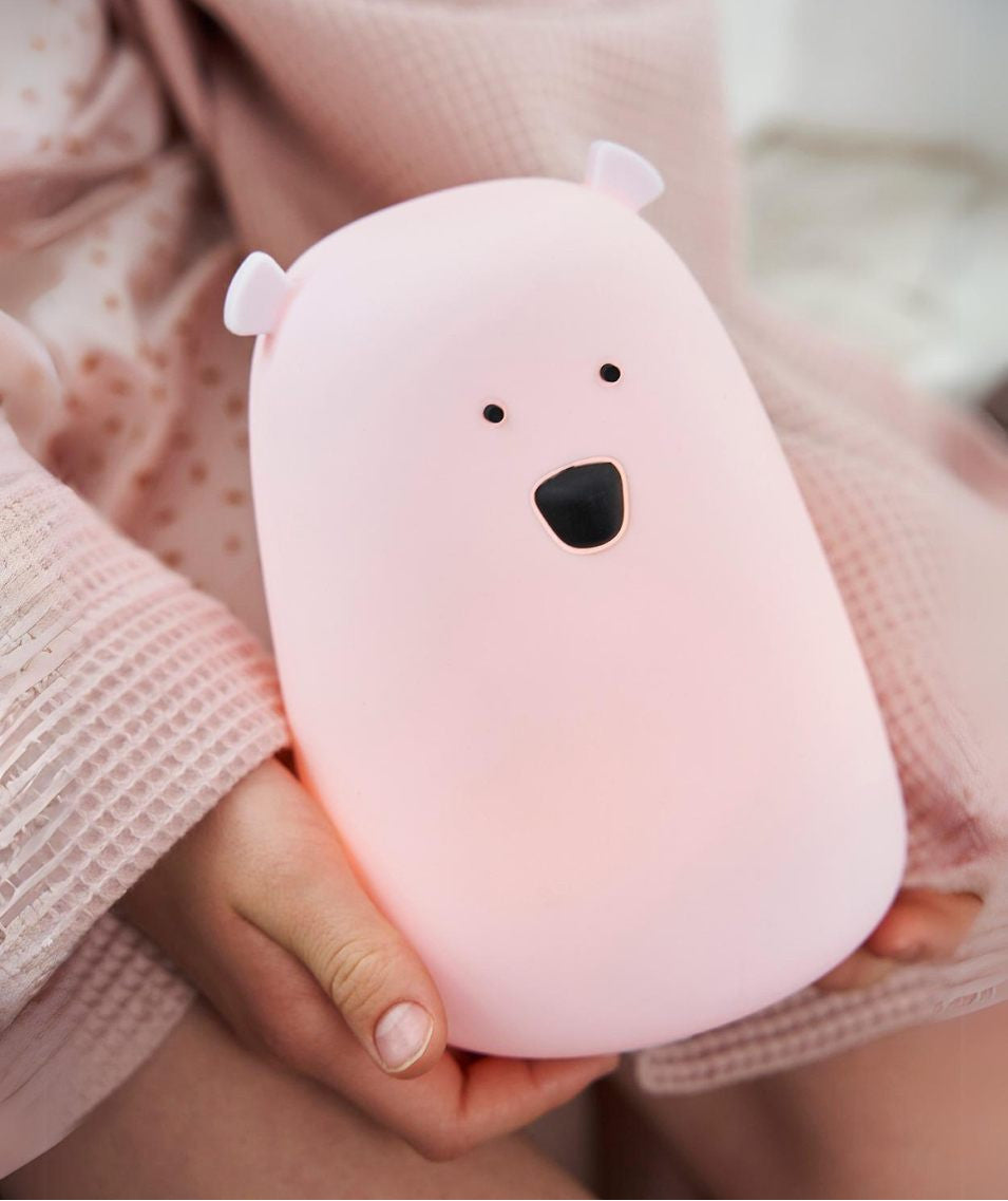 A person holding a pink Big Bear silicone lamp, featuring a charming teddy bear shape with friendly lighting for playtime and bedtime.