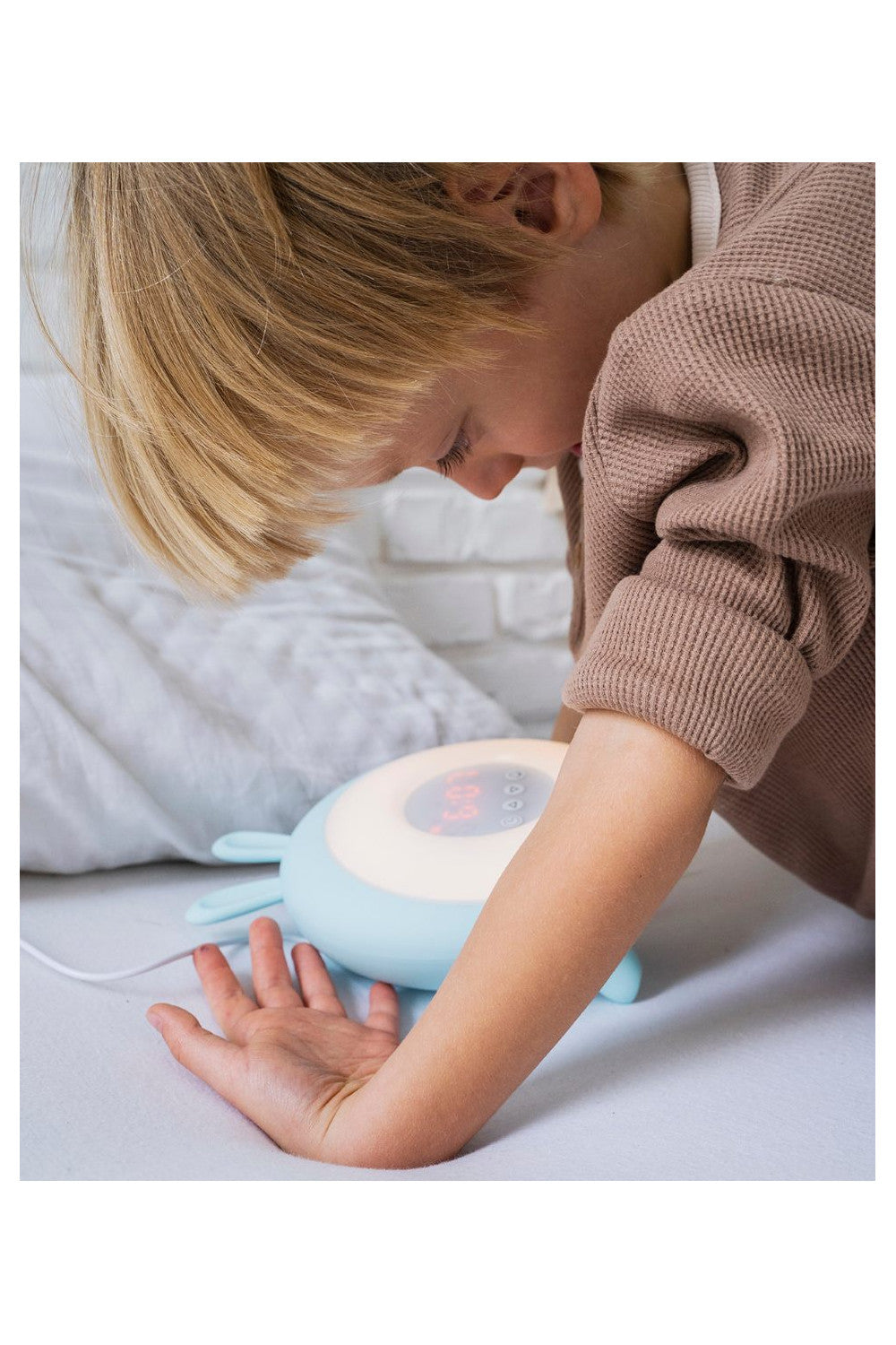 A child gazes at a Rabbit Lamp with Alarm Clock, featuring sunrise and sunset functions, gentle wake-up light, nature sounds, and touch controls.