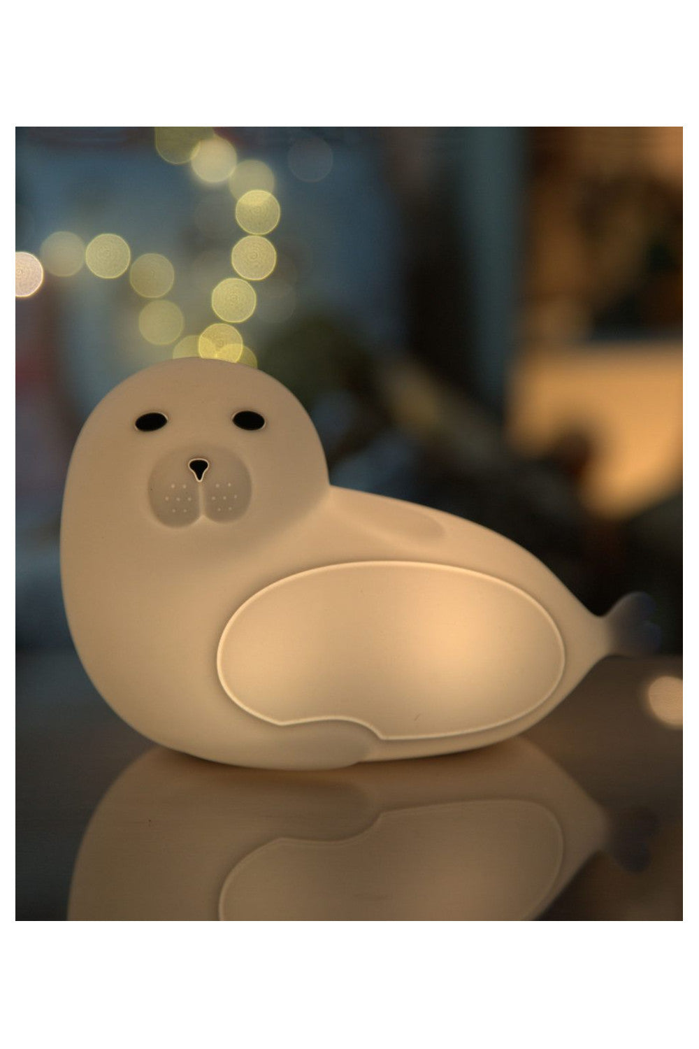 A white seal-shaped silicone lamp with remote control, safe for children, soft touch, 7 colors, 12-hour lighting, auto-off, USB-C charging.