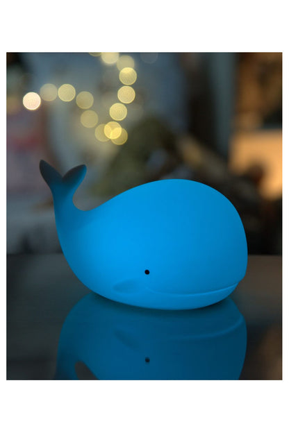 A soft, touchable Whale Silicone Lamp with Remote, perfect for children's comfort and safety at night. Features 7 colors, patting activation, and 12-hour lighting time. Dimensions: 8.9 x 13.6 x 10.8 cm.